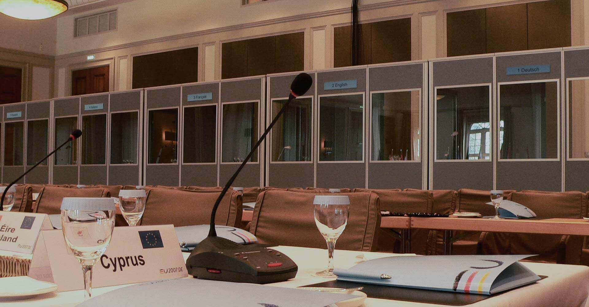 Dolmetscherkabinen und Mikrophone im Konferenzsaal