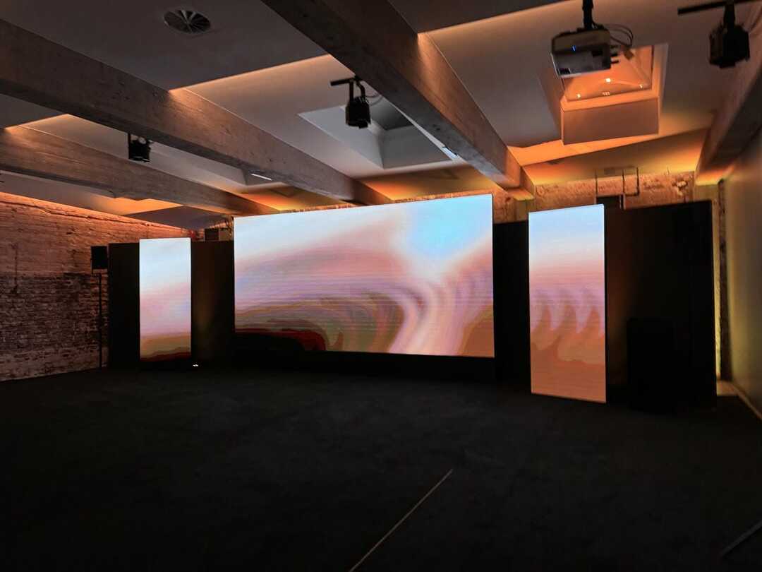 Großformatige Videoinstallation mit abstrakten Farbverläufen in industrieller Location