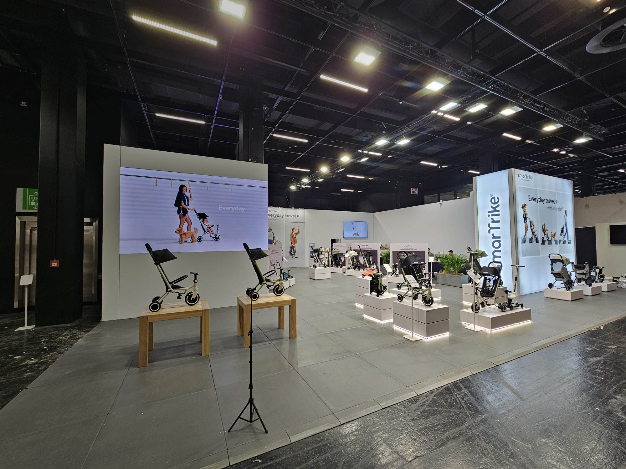 Moderner Messestand von smarTrike mit beleuchteten Produktpräsentationen und großformatigen LED-Wänden.