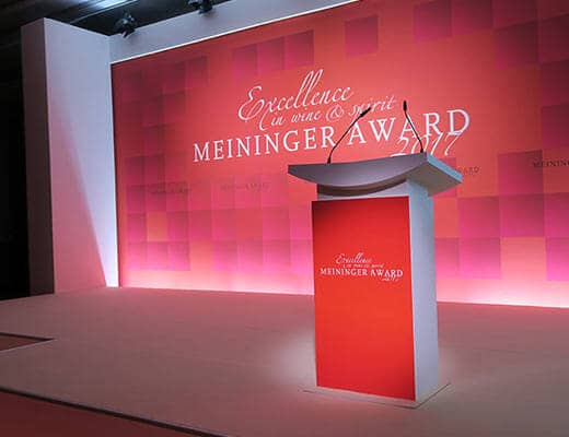 Rednerpult mit Meininger Award Logo und beleuchteter Rückwand im Hintergrund