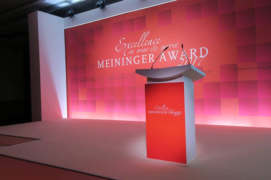 Rednerpult mit Meininger Award Logo und beleuchteter Rückwand im Hintergrund